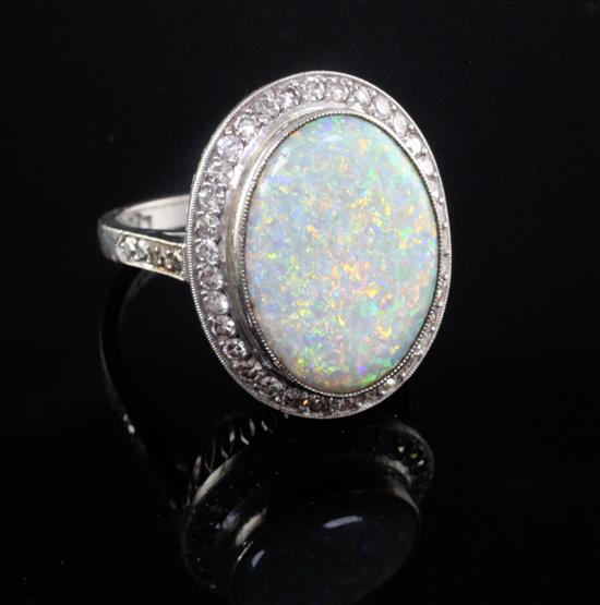 An 18ct gold and platinum, white opal and diamond set oval dress ring, size S.